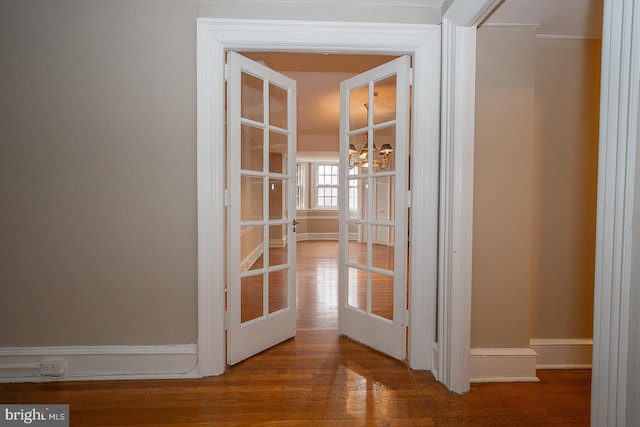 hall featuring baseboards and wood finished floors