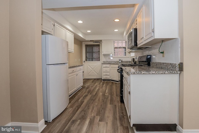 kitchen featuring recessed lighting, white cabinetry, appliances with stainless steel finishes, decorative backsplash, and dark wood finished floors