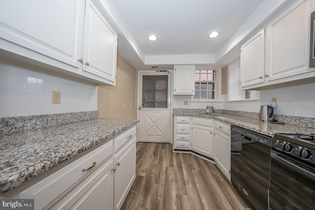 kitchen with black appliances, backsplash, white cabinets, and dark wood-style flooring