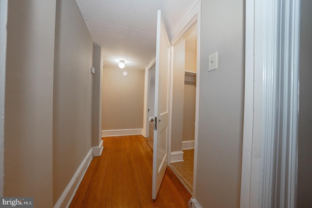 hall featuring baseboards and wood finished floors