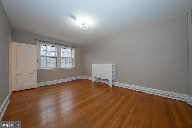 unfurnished room featuring hardwood / wood-style flooring and baseboards