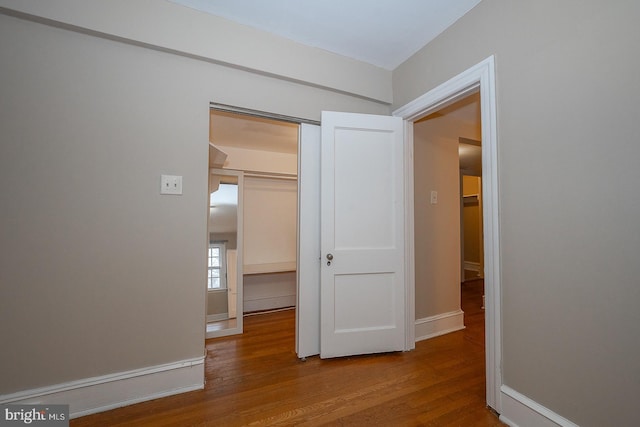 interior space with wood finished floors and baseboards