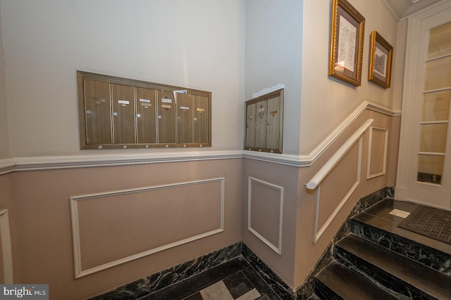 room details featuring mail area, a decorative wall, and wainscoting