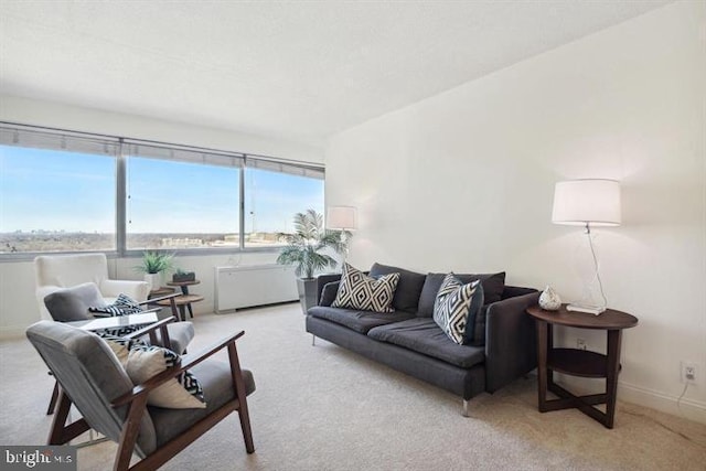 living area featuring carpet floors, radiator heating unit, and baseboards