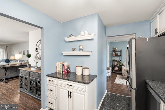 kitchen featuring baseboards, dark wood-type flooring, freestanding refrigerator, and white cabinetry