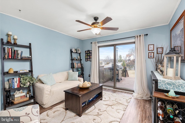 living room featuring ornamental molding, wood finished floors, and a ceiling fan