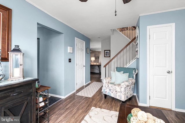 interior space with baseboards, stairway, wood finished floors, and crown molding