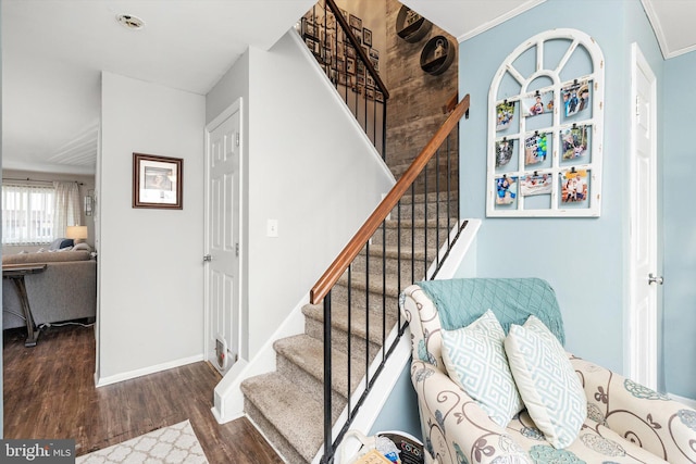 staircase with baseboards, wood finished floors, and ornamental molding