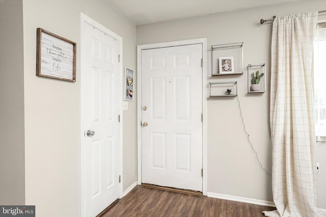 entryway with baseboards and dark wood-style flooring