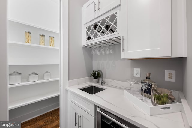 bar featuring indoor wet bar, a sink, and wood finished floors