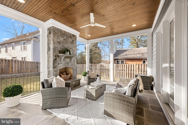 view of patio featuring an outdoor living space with a fireplace, a fenced backyard, and a ceiling fan