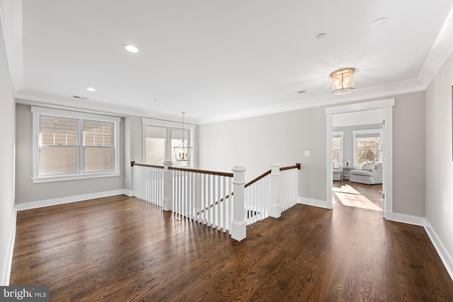 empty room featuring crown molding, recessed lighting, dark wood-type flooring, a chandelier, and baseboards