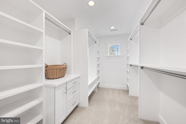 spacious closet featuring light carpet and visible vents