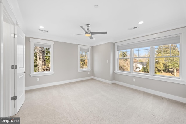 spare room with baseboards, visible vents, and light colored carpet