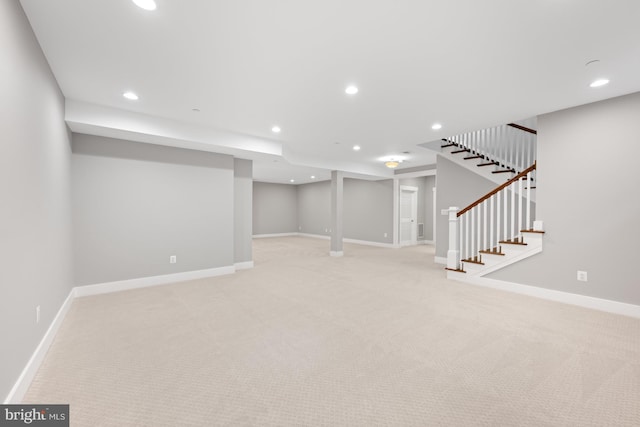 finished basement featuring recessed lighting, light carpet, baseboards, and stairs