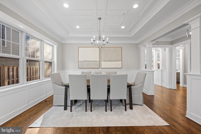 dining space with ornate columns, ornamental molding, a decorative wall, and dark wood-style flooring