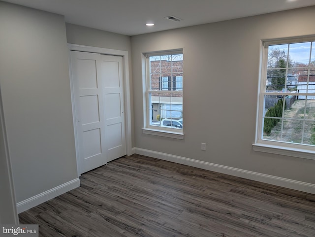 unfurnished bedroom featuring baseboards, a closet, recessed lighting, and dark wood-style floors