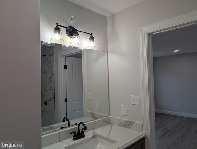 bathroom featuring baseboards, wood finished floors, and vanity