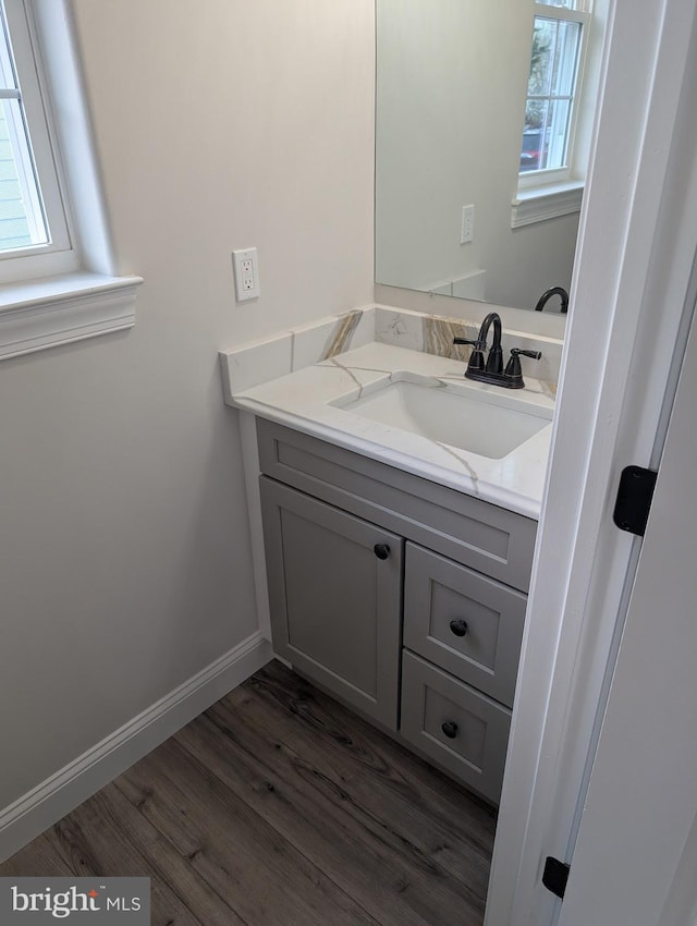 bathroom featuring baseboards, wood finished floors, and vanity