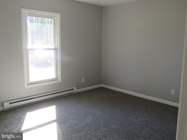 carpeted empty room with a baseboard heating unit and baseboards