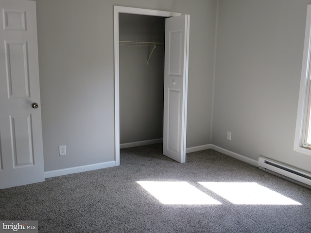 unfurnished bedroom with carpet floors, a closet, baseboards, and baseboard heating