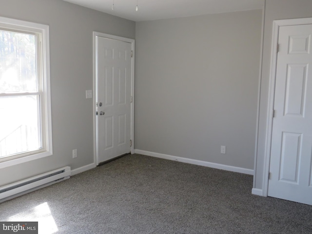 carpeted spare room with a baseboard radiator and baseboards