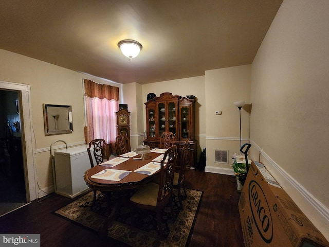 dining area with baseboards, visible vents, and wood finished floors