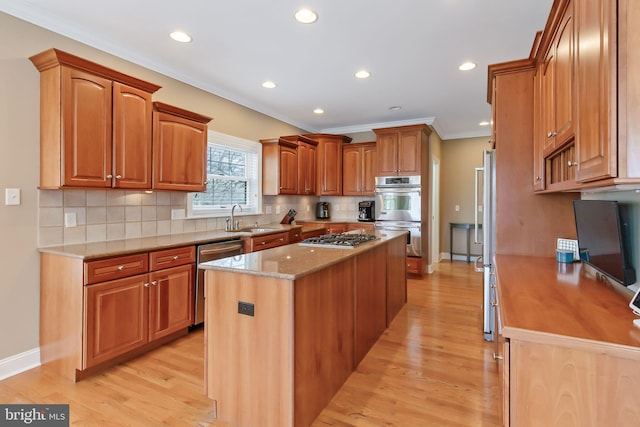 kitchen featuring stainless steel appliances, a center island, light wood-type flooring, and crown molding