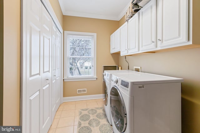 laundry room featuring light tile patterned floors, washing machine and dryer, visible vents, ornamental molding, and cabinet space