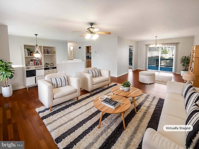 living area with ceiling fan with notable chandelier, baseboards, and wood finished floors