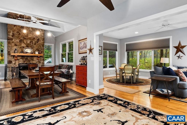 interior space with ceiling fan, a fireplace, baseboards, and wood finished floors