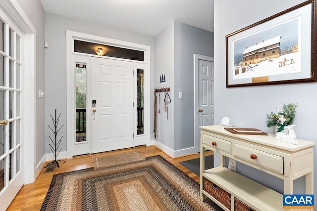 foyer entrance featuring baseboards and light wood finished floors