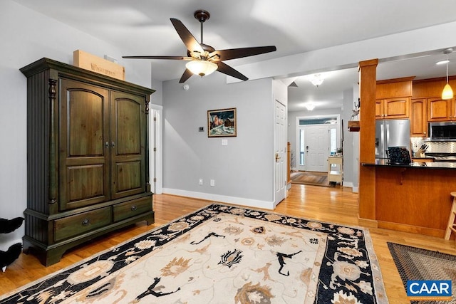 interior space with light wood-style floors, ceiling fan, and baseboards