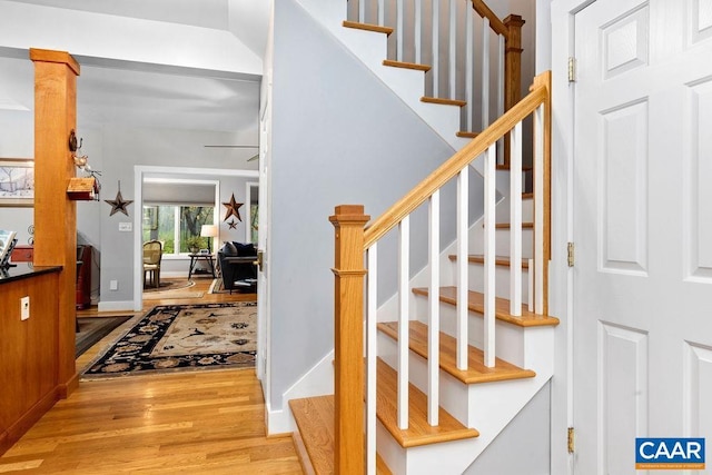 stairs with baseboards, decorative columns, a ceiling fan, and wood finished floors