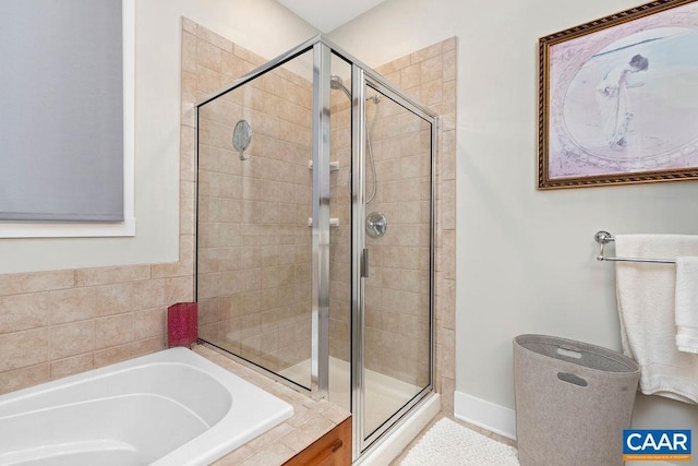 full bathroom with a stall shower and a bath