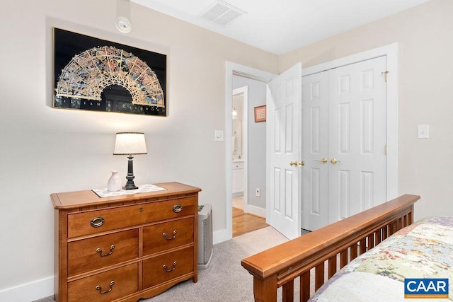 bedroom with baseboards, visible vents, a closet, and light colored carpet