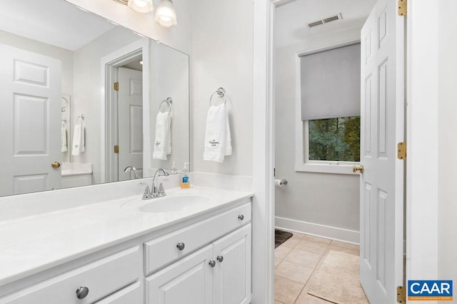 bathroom featuring visible vents, vanity, baseboards, and tile patterned floors