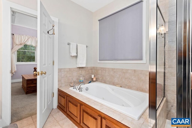 full bath with a whirlpool tub and tile patterned floors