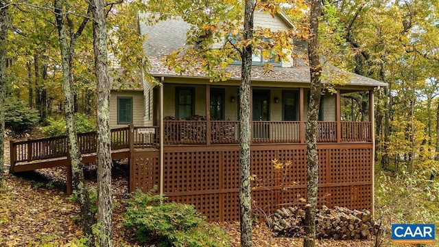 rear view of house featuring a porch and a shingled roof