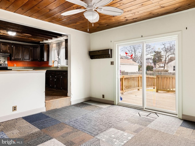 doorway to outside featuring light carpet, ceiling fan, a sink, wooden ceiling, and baseboards