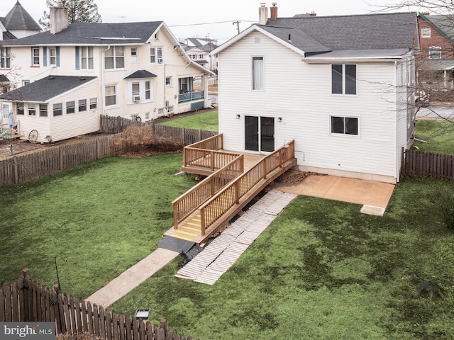 back of house with roof with shingles, a yard, a chimney, a deck, and a fenced backyard