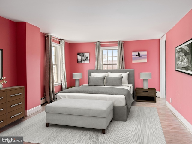 bedroom featuring a baseboard radiator, baseboards, and wood finished floors