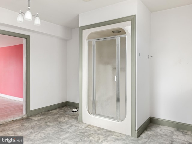 bathroom featuring a stall shower and baseboards