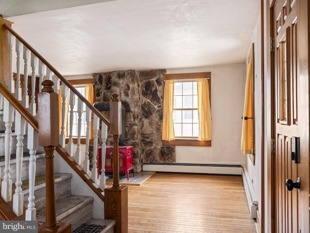 foyer featuring hardwood / wood-style flooring, a baseboard radiator, stairway, and a baseboard heating unit