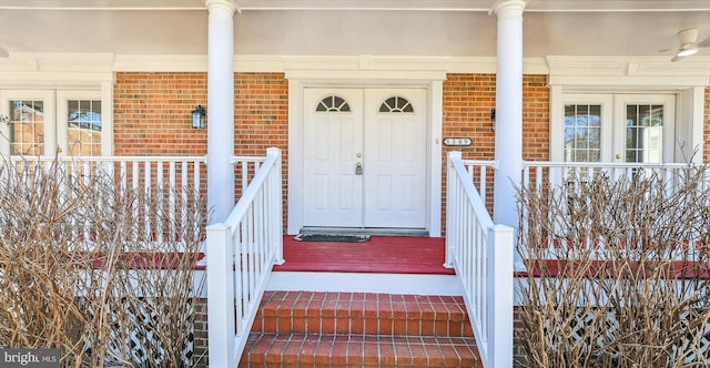 entrance to property featuring brick siding and a porch