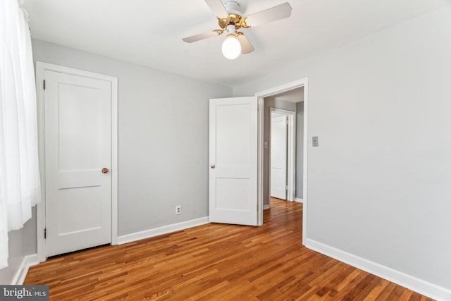 unfurnished bedroom featuring ceiling fan, wood finished floors, and baseboards