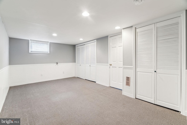 basement featuring carpet, a wainscoted wall, visible vents, and recessed lighting