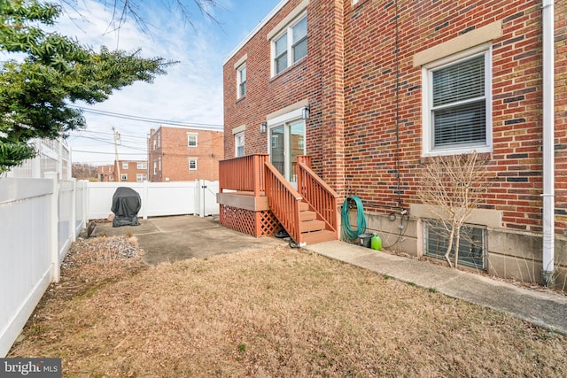 exterior space with a yard, brick siding, and a fenced backyard