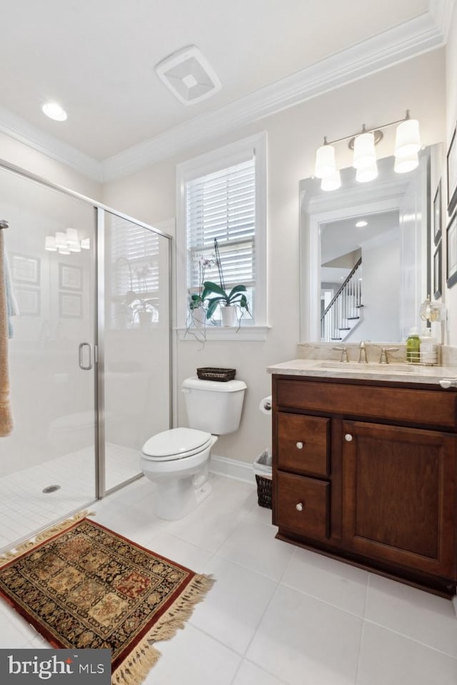 bathroom with tile patterned flooring, toilet, vanity, a shower stall, and crown molding