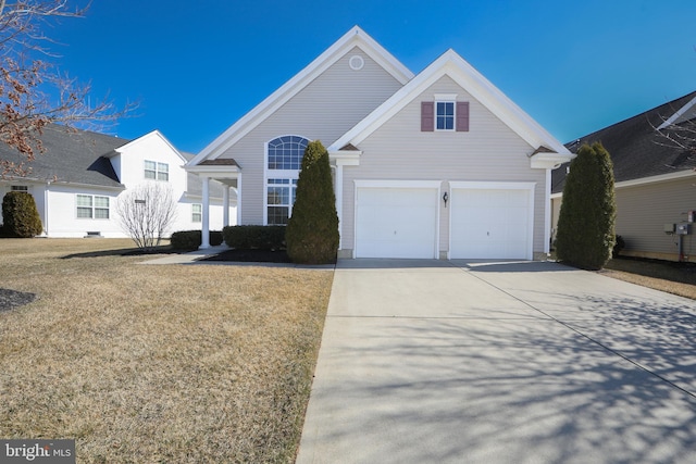 traditional-style home with a garage, concrete driveway, and a front yard